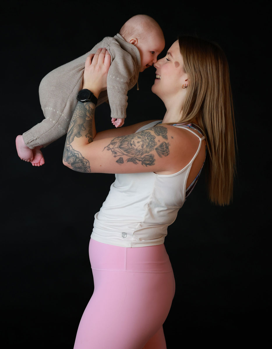 Treneren holder en baby.